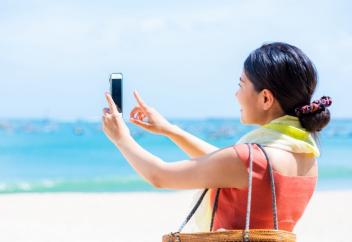 海の写真を撮る女性